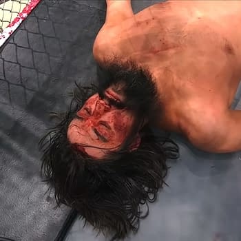 AEW Dynamite: Blood & Guts aftermath sees Wheeler Yuta lies on a wrestling mat, visibly defeated and bloodied, after a brutal Blood and Guts match. The surrounding area shows signs of violence, adding to the scene's intensity.