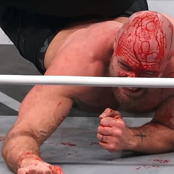 Jon Moxley, visibly injured and bleeding, struggles on the mat during a Continental Classic match against Claudio Castagnoli on AEW Dynamite, showcasing an intense moment of wrestling.