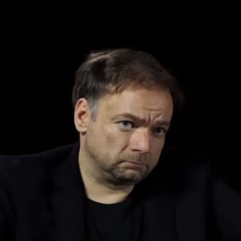 André Øvredal with short, slightly tousled hair and a serious expression is seated against a black background.