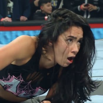 AJ Lee shows a passionate expression as she celebrates defeating Becky Lynch to win the Intercontinental Championship at the WWE Elimination Chamber event, capturing the emotional moment in the wrestling ring.
