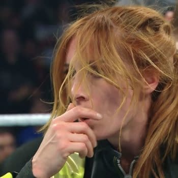 Becky Lynch shows visible frustration during her match with AJ Lee at WWE Elimination Chamber, her hand covering her mouth in a moment of contemplation.