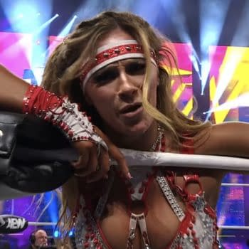 Megan Bayne, wearing a sparkling red and silver wrestling outfit, leans against the ropes of a wrestling ring with a determined expression after winning the AEW Women's Tag Team Championship at AEW Revolution. Colorful lights and an excited crowd are in the background.