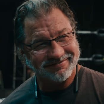 Al Snow, former WWE star, smiles while wearing glasses and a headset, with wrestling ring ropes visible in the background. He appears in a Netflix documentary about wrestling.