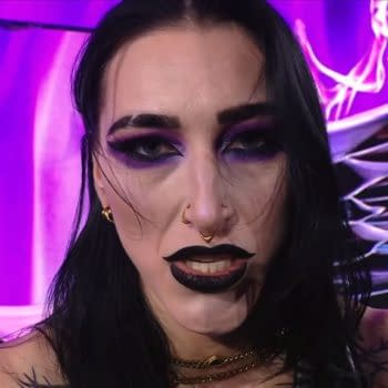 Rhea Ripley shows a fierce expression during her appearance on WWE Raw, with dramatic makeup featuring bold black lips and striking eye color against a purple background.