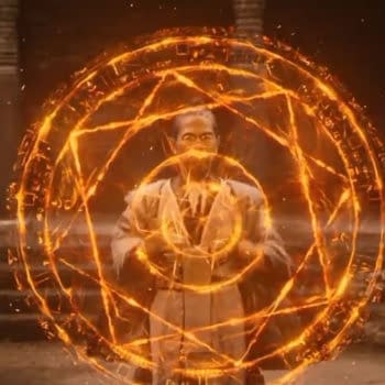 Doctor Strange’s Master Hamir stands inside a glowing orange magical shield, facing two other figures in a temple-like setting.