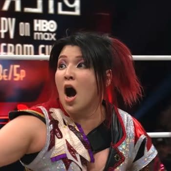 Hikaru Shida, a professional wrestler, expresses surprise in the ring during her first AEW match in over a year. She is wearing a colorful wrestling outfit with an ornate design and her hair is styled with bright red highlights.