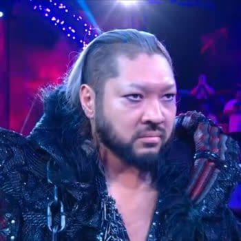 EVIL stands in a WWE NXT ring under purple lighting, wearing a dark, elaborate entrance outfit. He stares ahead during his debut appearance.