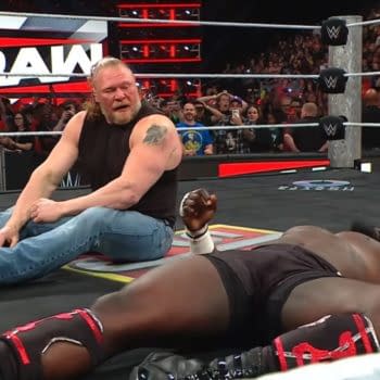 Brock Lesnar sits on the WWE Raw ring mat after a brutal attack, with Oba Femi lying motionless nearby and the crowd watching from behind the ropes.
