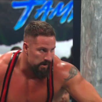 Bron Breakker crouches and prepares to launch a spear outside the ring at WWE Backlash. He looks intense and focused beside the ring post.