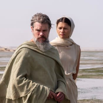Matt Damon as Odysseus and Zendaya as Athena stand together in desert-like coastal scenery in The Odyssey.