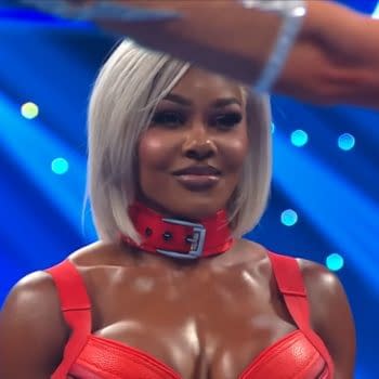 Jade Cargill stands on WWE SmackDown with a unimpressed look as an arm gestures in front of her, under blue stage lights.