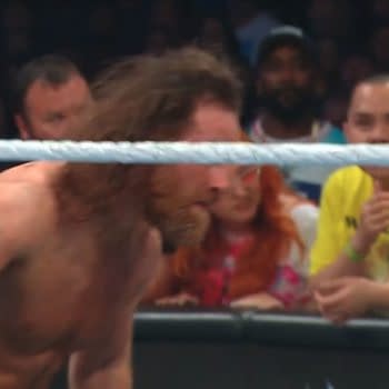 Sami Zayn crouches in the ring, charging up for a Helluva Kick during WWE Backlash while the crowd watches from behind the ropes.