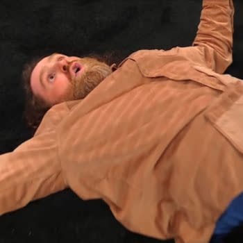 Sami Zayn lies sprawled on the mat after a candy cane attack at a WWE SmackDown funeral segment, wearing a tan jacket and blue shirt. The WWE and USA Network logos appear in the corner.