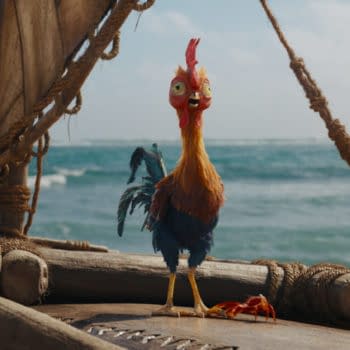 Rooster Heihei stands on a wooden boat deck in Disney’s live-action Moana, with the ocean behind him.
