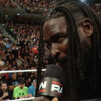 Oba Femi speaks into a WWE Raw microphone inside the ring, with a packed arena crowd behind him. He appears to be issuing a SummerSlam challenge.