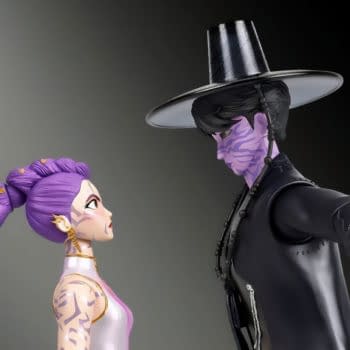 KPop Demon Hunters Rumi and Jinu figure 2-pack posed face to face, with Rumi’s purple braid and Jinu’s black hat and dark outfit. Their matching purple markings stand out against a plain background.