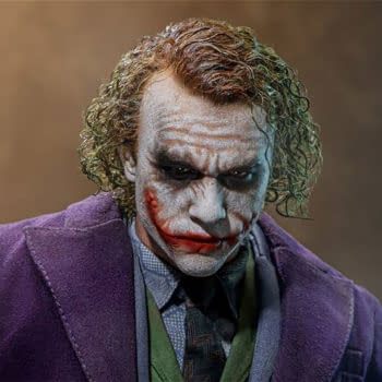 Hot Toys Artisan Edition 1/4 Scale The Joker 2.0 figure with a pale, scarred face, green hair, and a purple suit. The collectible has a grim, realistic expression and detailed costume design.