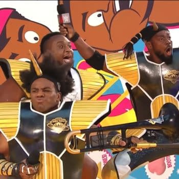The New Day make a colorful WrestleMania 32 entrance in matching gold-and-black armor, striking animated poses in front of a giant cartoon-style backdrop.