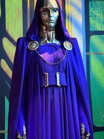 A silver-masked figure in a purple hooded costume stands on an SDCC display stage, likely a Marvel Avengers: Doomsday character reveal.