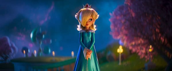 A stylized animated character resembling a princess with blonde hair and a crown, wearing a blue gown, stands in a whimsical, softly lit landscape filled with pink trees and glowing lights.