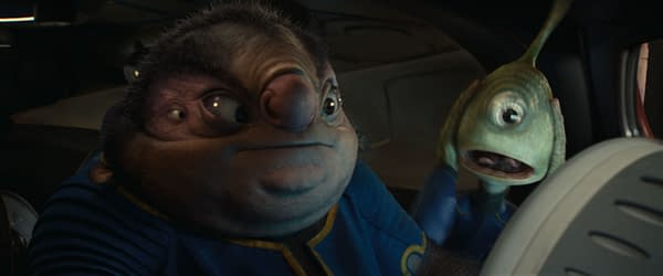 In a scene from Disney's live-action 'Lilo & Stitch,' Jumba, a large alien with a blue outfit, looks concerned while holding Pleakley, a small green alien with a distressed expression. Both characters are in a spaceship interior.