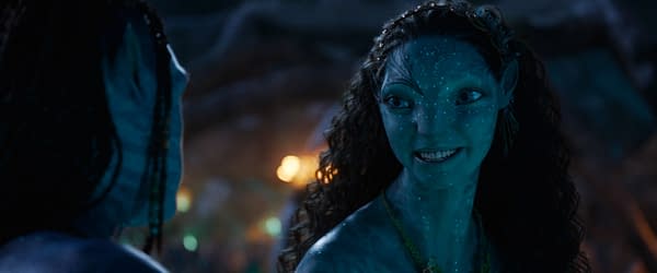 A scene from 'AVATAR: FIRE AND ASH' featuring two Na'vi characters, Lo'ak and Tsireya, engaged in a friendly conversation. They have distinctive blue skin and decorative elements in their hair and clothing.