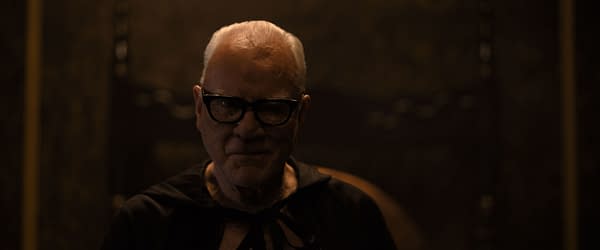 Malcolm McDowell portrays Mr. Pendleton in a dark setting from 20th Century Studios' film "Psycho Killer", featuring a sinister expression and wearing a black outfit.
