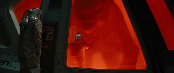 In a science fiction scene, two astronauts observe a large dinosaur through a glowing red containment window, evoking a sense of suspense and discovery. The environment features futuristic elements and an intense color palette.