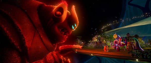 An animated scene from Disney and Pixar's 'Elio' featuring Lord Grigon, a large, imposing alien warlord with red and purple tones, towering over a vibrant alien landscape filled with colorful creatures and plants, while Elio, a smaller character, stands with companions in the foreground.