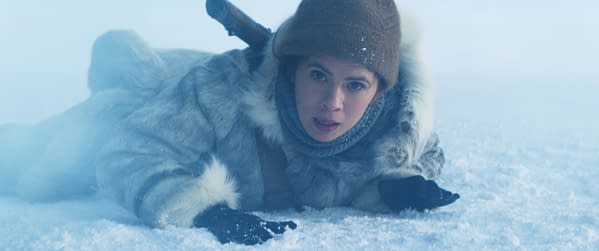 A scene from 'Mission: Impossible - The Final Reckoning' featuring Hayley Atwell as Grace, dressed in a fur coat and hat, lying in a snowy, icy environment, with a look of determination on her face.