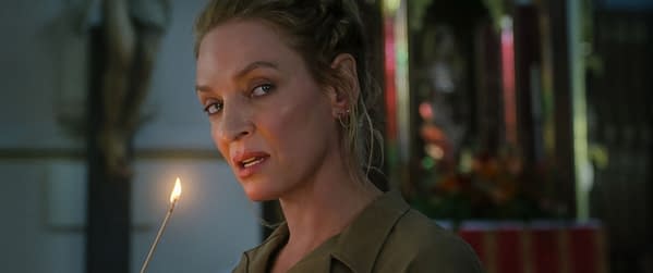 Uma Thurman portrays the character Discord in a scene from 'The Old Guard 2', holding a lit stick while looking intently off-screen.