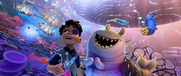A vibrant animated scene featuring Elio, a young boy with a blue eye patch, joyfully holding a glass filled with colorful liquid. Beside him is Glordon, a large, friendly creature with a wide grin and sharp teeth, surrounded by an otherworldly landscape with floating jellyfish-like plants and whimsical alien beings.