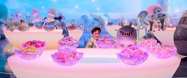 In a vibrant animated scene from Disney and Pixar's 'Elio,' a cheerful boy named Elio, surrounded by colorful alien characters, delights in a table full of sparkling treats and desserts. This whimsical setting showcases the film's imaginative landscape as Elio embarks on his intergalactic adventures.