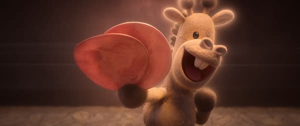 A cheerful cartoon stuffed giraffe waving two pink circular objects, set against a dark background. This character is part of the comedy adventure 'In Your Dreams', which features whimsical elements as siblings navigate their dream landscapes.