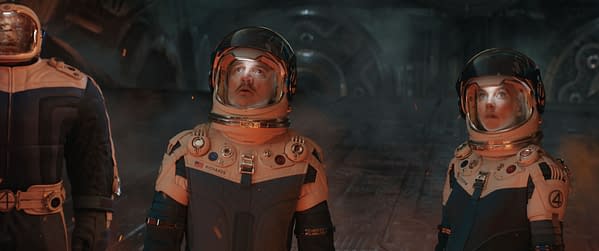 A still from 'The Fantastic Four: First Steps' featuring three characters in futuristic space suits, with one character named Reed Richards/Mister Fantastic at the center, looking surprised. The setting conveys a dramatic and adventurous atmosphere, hinting at the Marvel Studios narrative.