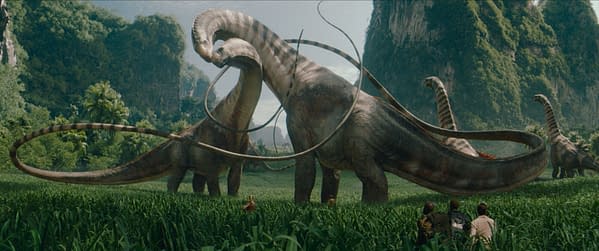 A digital illustration from 'Jurassic World Rebirth' featuring large dinosaur-like creatures in a lush green landscape, with a group of human figures in the foreground observing them.
