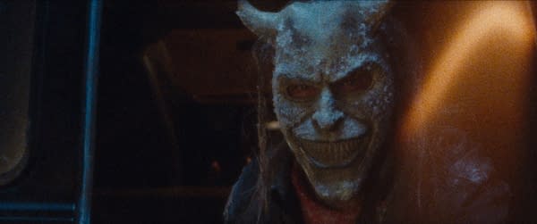 The Grabber, a character from the film Black Phone 2, is shown wearing a menacing mask with a wide grin and prominent horns, set against a dark background that enhances the eerie atmosphere.