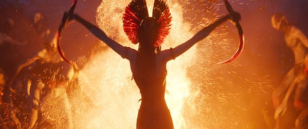In the film 'Avatar: Fire and Ash,' Varang, portrayed by Oona Chaplin, is depicted in a dramatic scene surrounded by fire and sparks, emphasizing an intense and mystical atmosphere.
