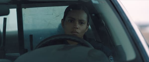 A scene from 'Psycho Killer' featuring Georgina Campbell as Jane Archer, who appears serious and intense while seated in a police car. The atmosphere suggests tension, fitting for the film's genre.