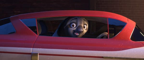 An animated cartoon character, Flash Slothmore, is seen smiling from the driver's seat of a bright red car in a scene from Disney's "Zootopia 2." This character, known for his slow demeanor, appears cheerful and friendly.