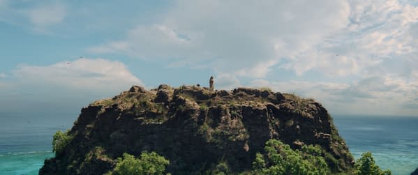 A dramatic landscape featuring a rocky cliff overlooking the ocean, with Catherina Laga'aia as Moana standing at the edge. The scene is set against a sky filled with clouds, capturing the adventurous spirit of Disney's live-action Moana.