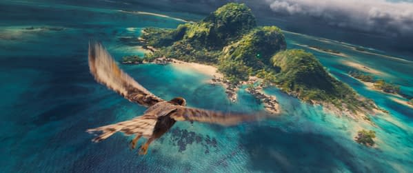 A scene from Disney's live-action Moana, featuring a bird soaring over a vibrant turquoise ocean and lush green island landscapes.