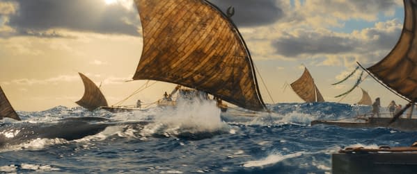 A scene from Disney's live-action Moana, featuring traditional sailing canoes navigating through vibrant ocean waves under a cloudy sky. The image captures the energy of the sea and the adventure of exploration.