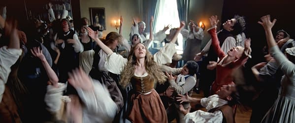 A scene from 'The Testament of Ann Lee' featuring Amanda Seyfried in a dramatic moment among a chaotic ensemble of characters, all expressing intense emotions in an animated gathering.