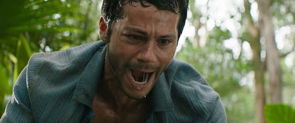 A still from 20th Century Studios' film "SEND HELP," featuring Dylan O'Brien as Bradley Preston, who appears distressed and is shouting for help in a dense, green jungle setting.
