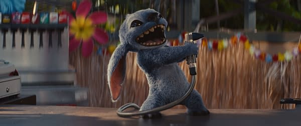 Stitch, the mischievous alien character from Disney's Lilo & Stitch, is seen energetically holding a device in his hand, surrounded by colorful decorations and backgrounds that evoke a lively setting.