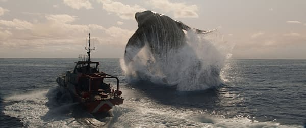 A cinematic scene from 'Jurassic World Rebirth' depicts a large creature, resembling a whale, breaching dramatically near a boat in the ocean, creating a splash and showcasing the vast water and sky.