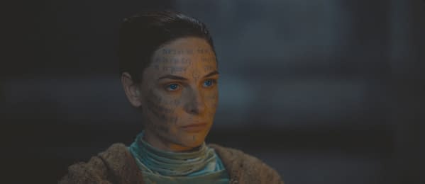 A character with intricate markings on her face and striking blue eyes, wearing a textured garment, set against a dark background. This image is associated with the post titled 'Dune: Part Three'.