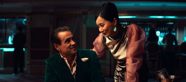 A scene from 'Ballad of a Small Player' featuring two characters in an elegant setting, with a man in a green velvet jacket and a woman in a metallic outfit engaging in conversation, conveying a sense of intimacy and intrigue.