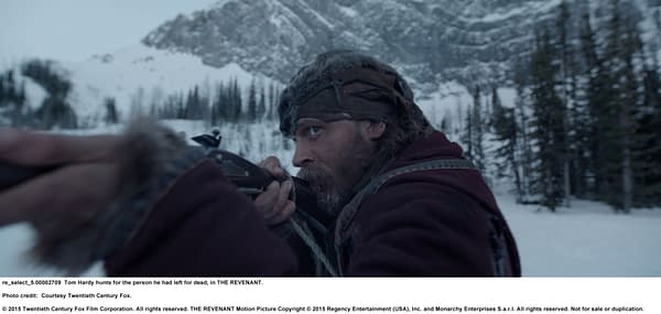 Still from the film THE REVENANT, featuring Tom Hardy aiming a weapon in a snow-covered landscape, conveying a sense of tension and urgency.